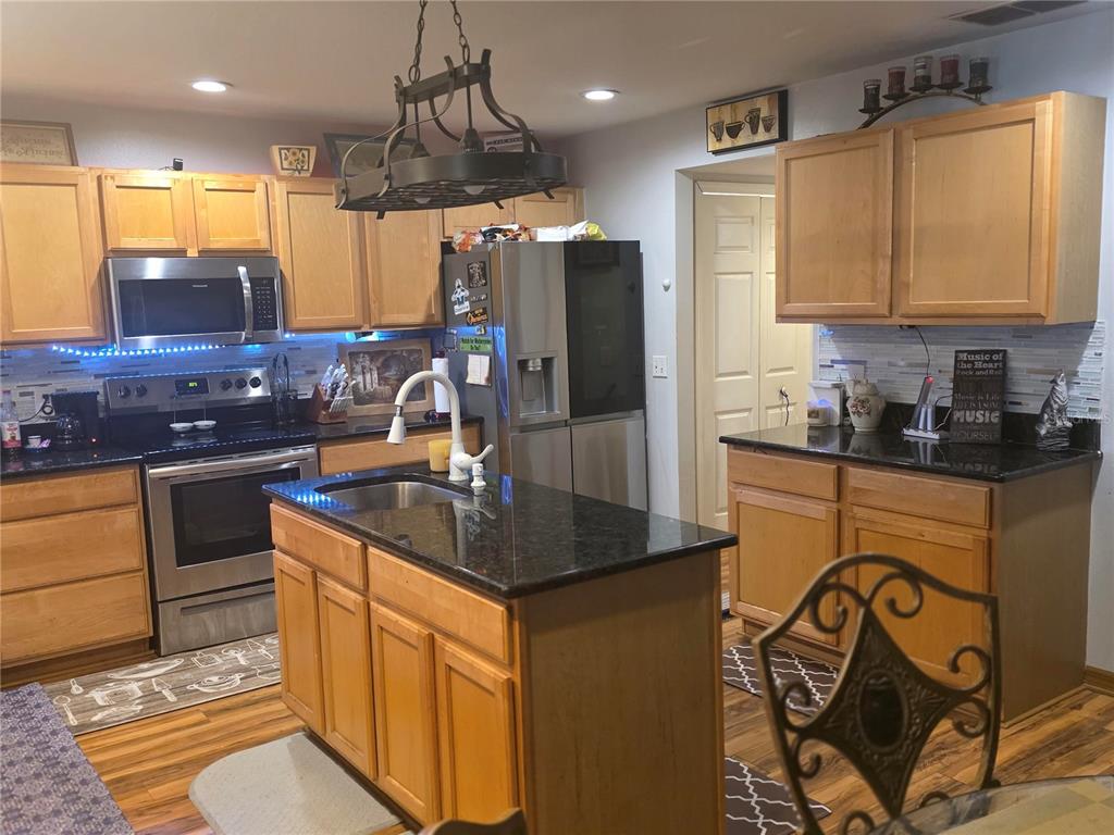 959 Thomas Road Eagle Lake, FL 33839 - Photo 13 of 35 a kitchen with stainless steel appliances granite countertop a sink and a refrigerator