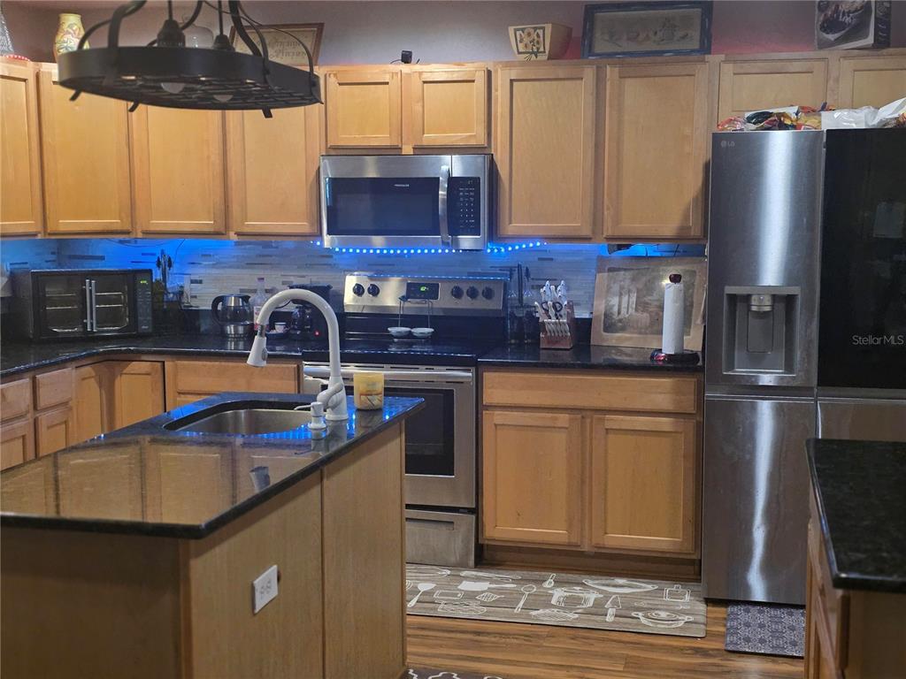959 Thomas Road Eagle Lake, FL 33839 - Photo 15 of 35 a kitchen with stainless steel appliances granite countertop a sink stove and refrigerator