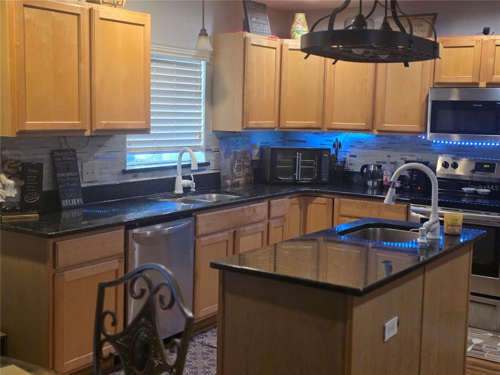 959 Thomas Road Eagle Lake, FL 33839 - Photo 16 of 35 a kitchen with stainless steel appliances granite countertop a sink a stove and a microwave