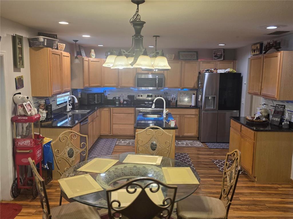 959 Thomas Road Eagle Lake, FL 33839 - Photo 7 of 35 a kitchen with stainless steel appliances granite countertop a refrigerator a stove a sink dishwasher with a dining table and chairs