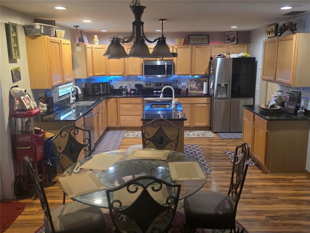 959 Thomas Road Eagle Lake, FL 33839 - Photo 10 of 35 a kitchen with stainless steel appliances kitchen island granite countertop a table chairs and a refrigerator