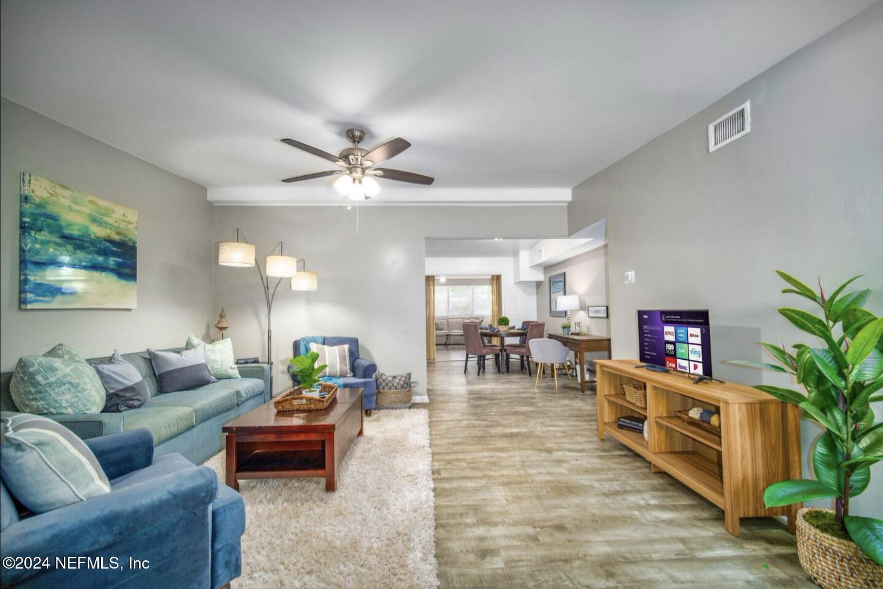 7466 Proxima Road Jacksonville, FL 32210 - Photo 12 of 34 a living room with furniture and a chandelier