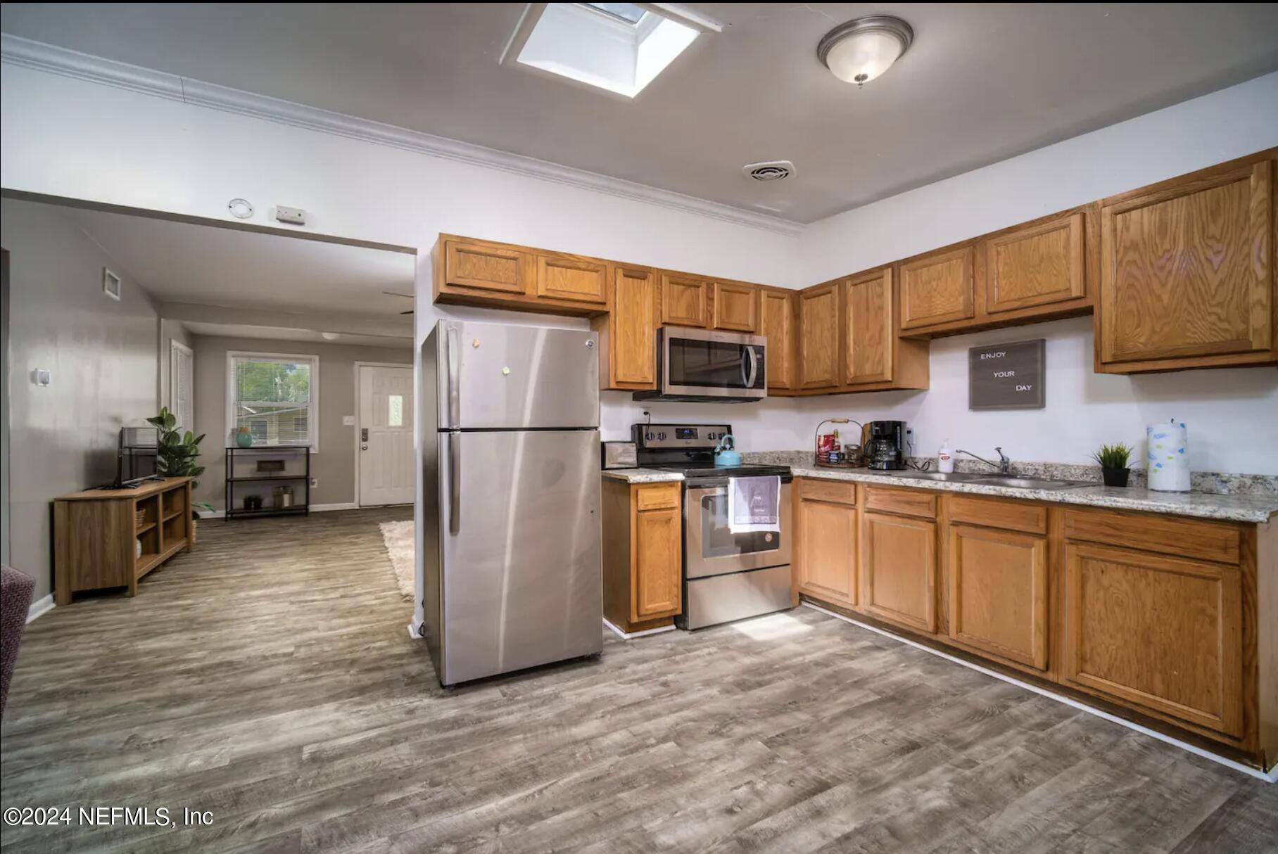 7466 Proxima Road Jacksonville, FL 32210 - Photo 14 of 34 a kitchen with refrigerator cabinets and wooden floor