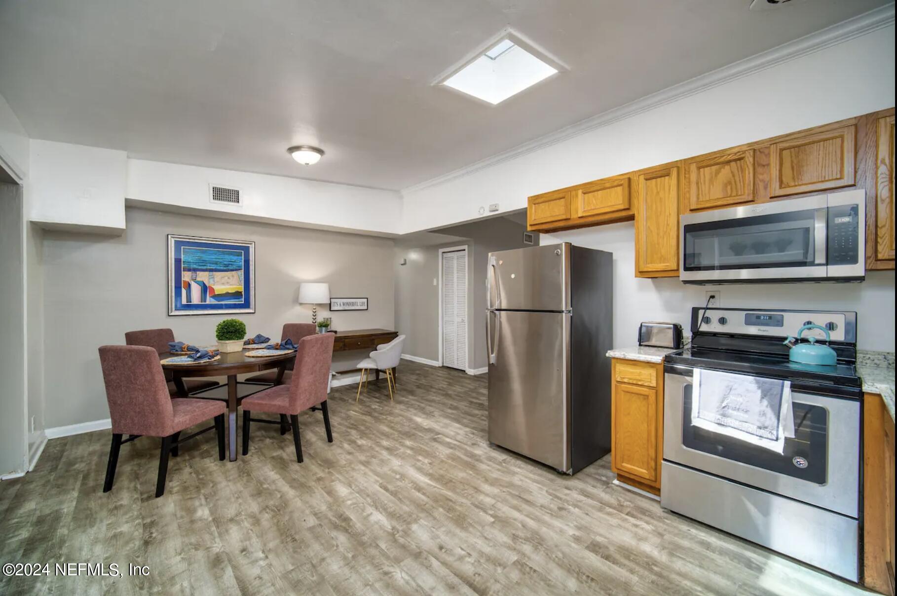 7466 Proxima Road Jacksonville, FL 32210 - Photo 15 of 34 a living room with furniture a flat screen tv and a refrigerator