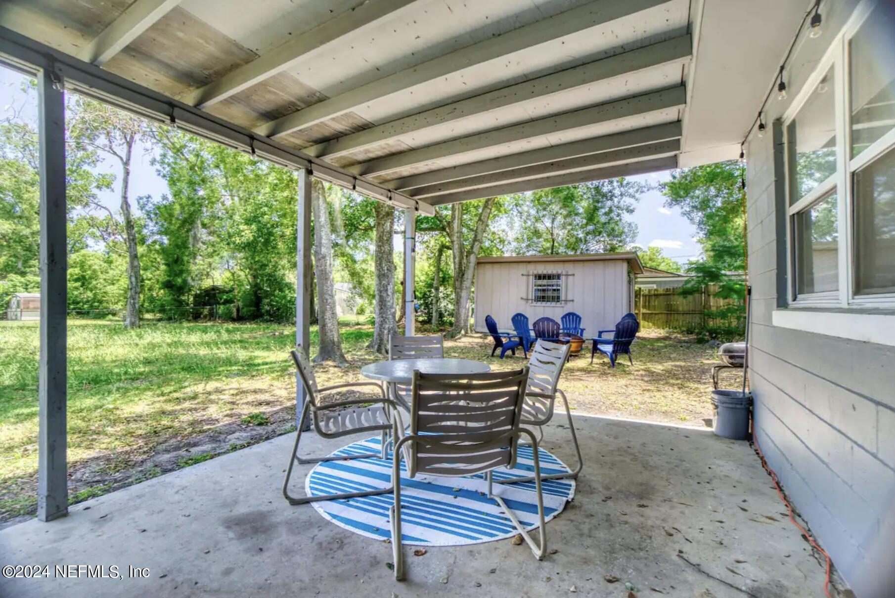 7466 Proxima Road Jacksonville, FL 32210 - Photo 30 of 34 a view of a patio with a table chairs and a backyard