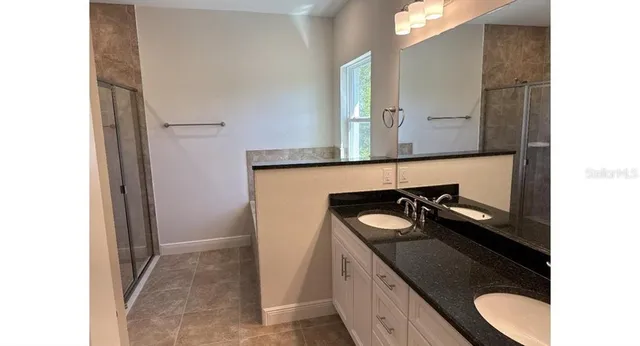 a bathroom with a granite countertop sink and a mirror