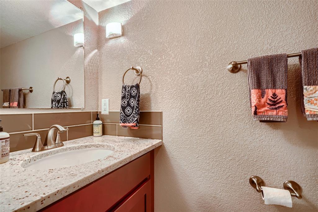 4140 Decatur Street Denver, CO 80211 - Photo 23 of 33 a bathroom with a granite countertop sink a mirror and shower