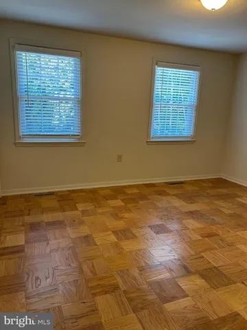 a view of an empty room with window and chandelier fan