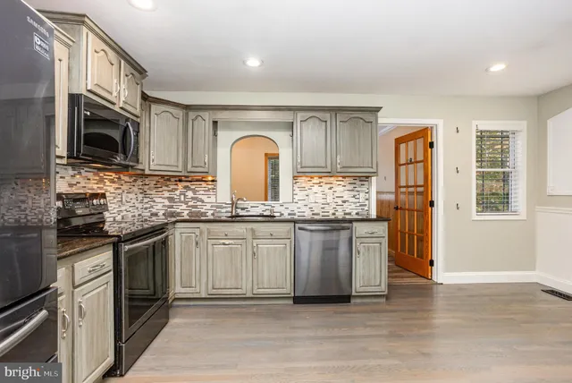 an empty room with windows and ceiling fan