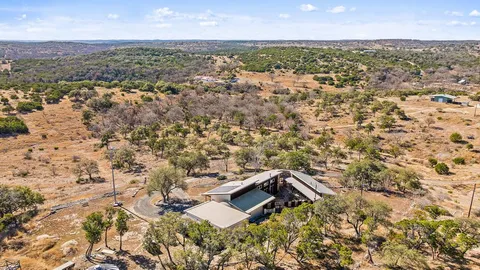 an aerial view of house with yard and mountain view in back