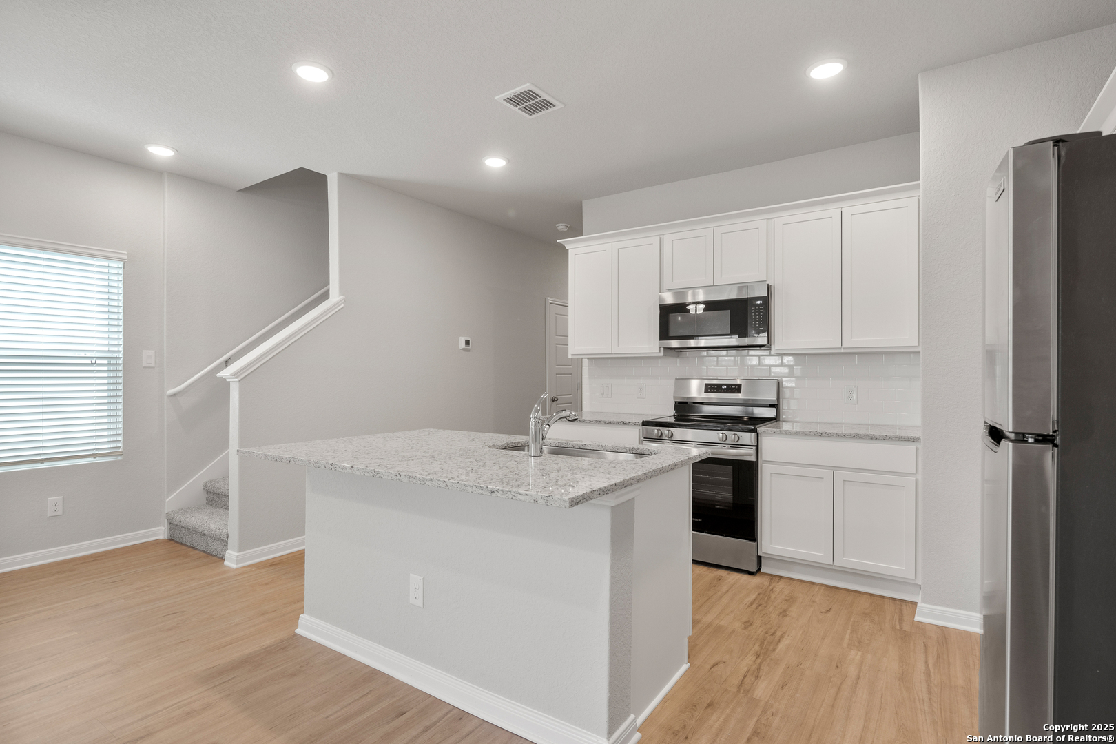 3924 Abbott Pass, Unit 101 St. Hedwig, TX 78152 - Photo 6 of 17 a kitchen with a sink a stove a refrigerator and cabinets