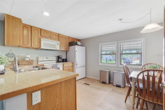 a kitchen with a table chairs refrigerator and cabinets