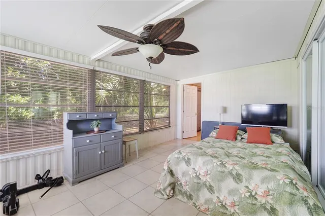 a bedroom with a large bed and a flat tv screen