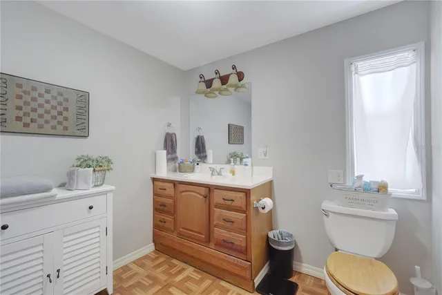 a bathroom with a toilet a sink and mirror