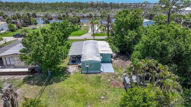 an aerial view of a house with a yard and large tree