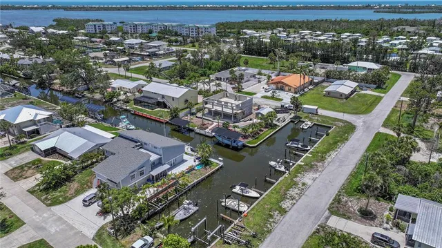 an aerial view of a city with lots of residential buildings ocean and mountain view in back