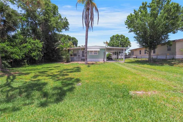 a view of a house with a yard and sitting area