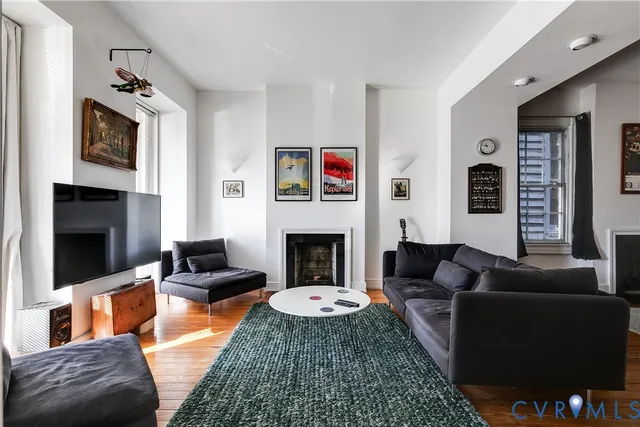 a living room with furniture a flat screen tv and a fireplace