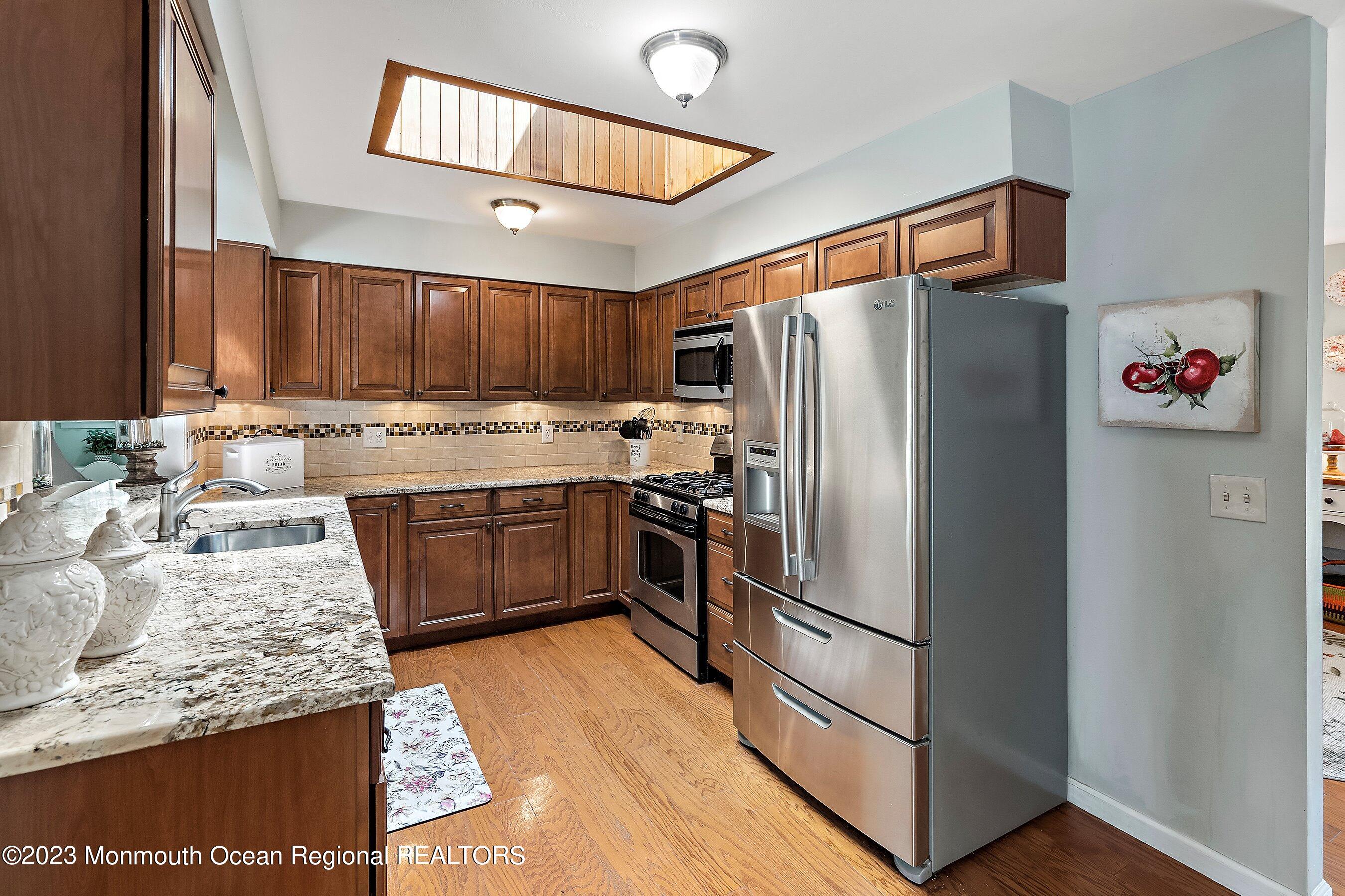370 Constitution Drive Forked River, NJ 08731 - Photo 11 of 25 a kitchen with granite countertop a refrigerator stove and sink
