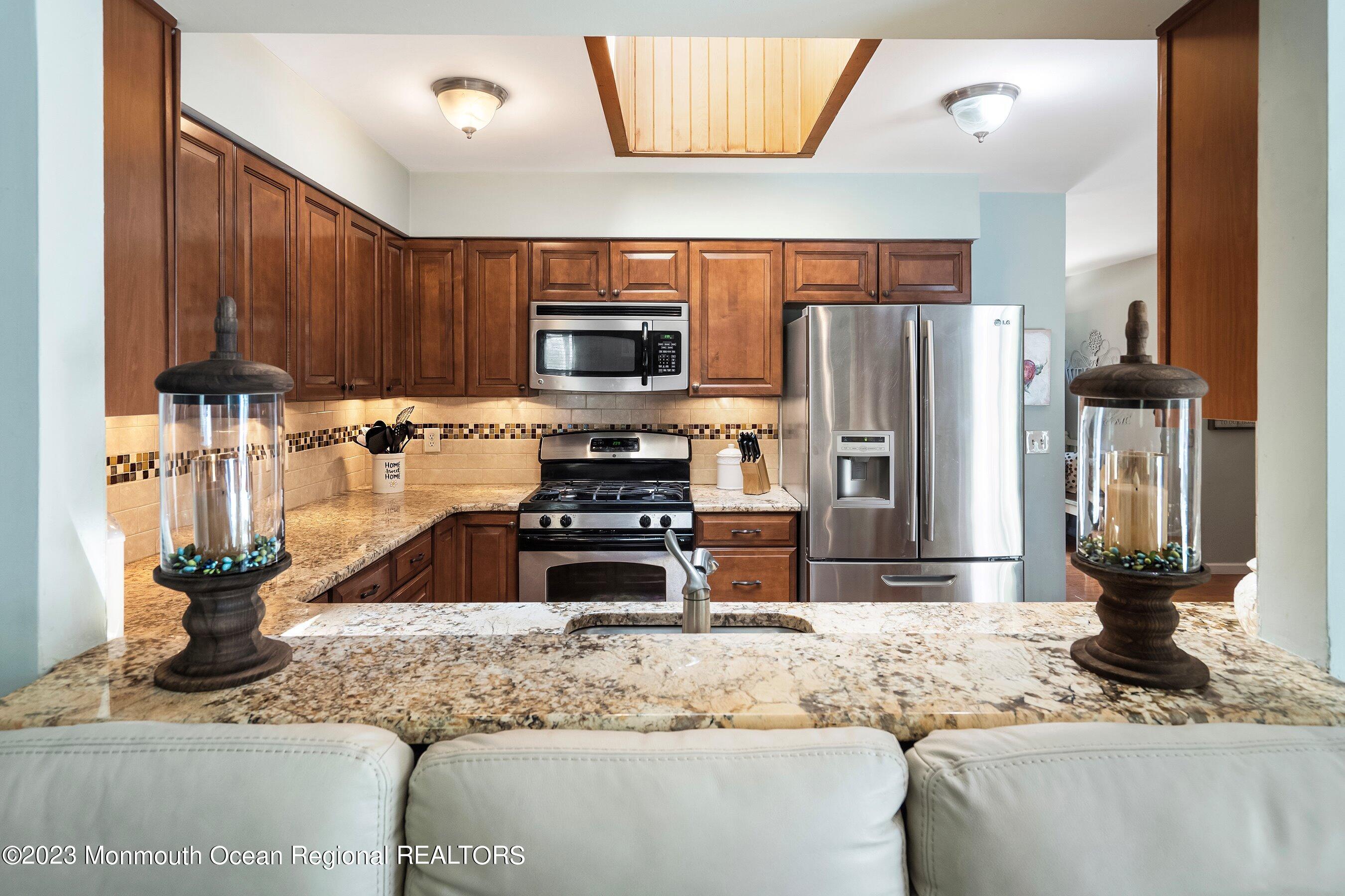 370 Constitution Drive Forked River, NJ 08731 - Photo 8 of 25 a kitchen with kitchen island granite countertop a sink stainless steel appliances and cabinets