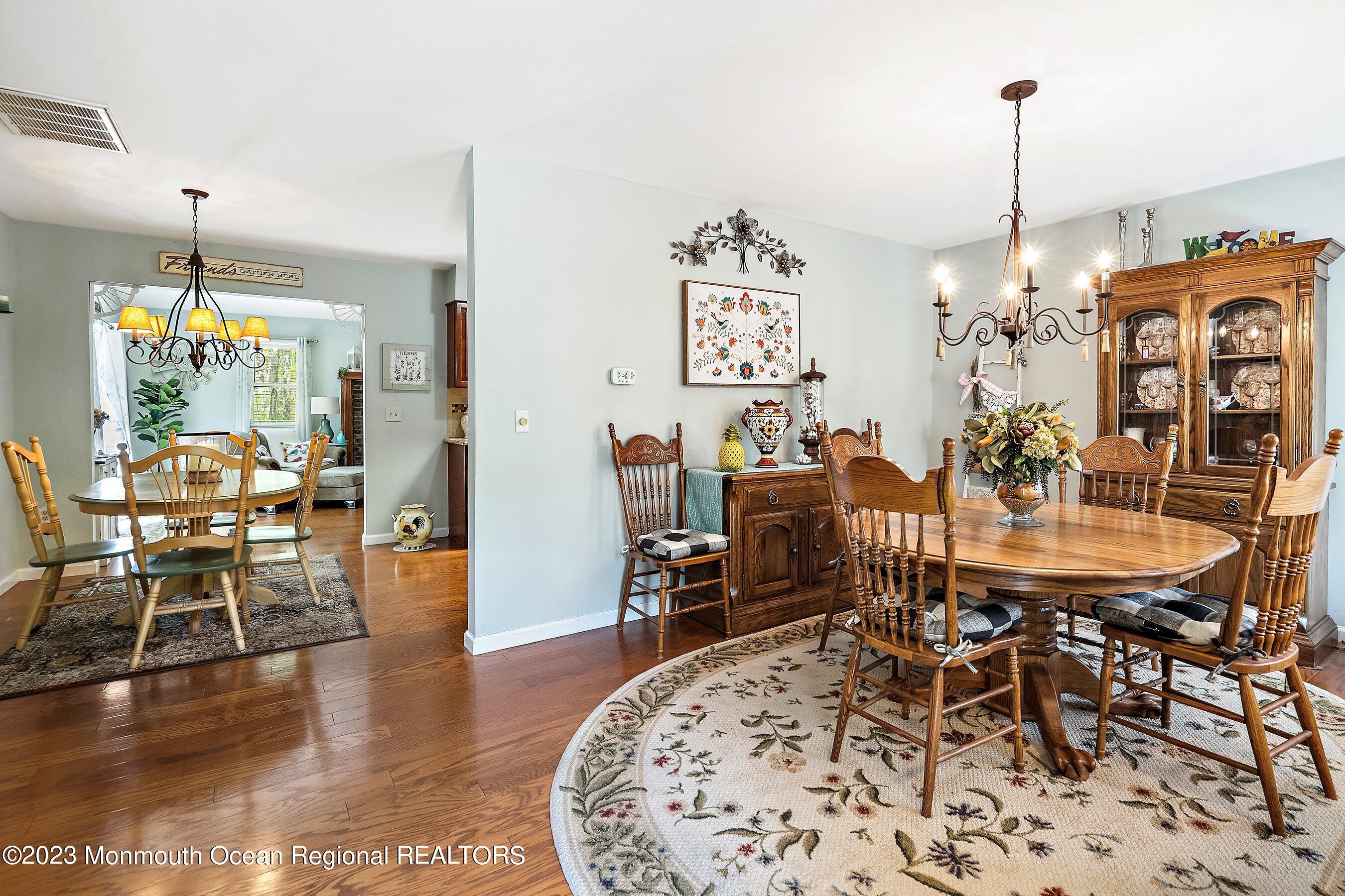 370 Constitution Drive Forked River, NJ 08731 - Photo 10 of 25 a view of a dining room and livingroom with furniture wooden floor a chandelier