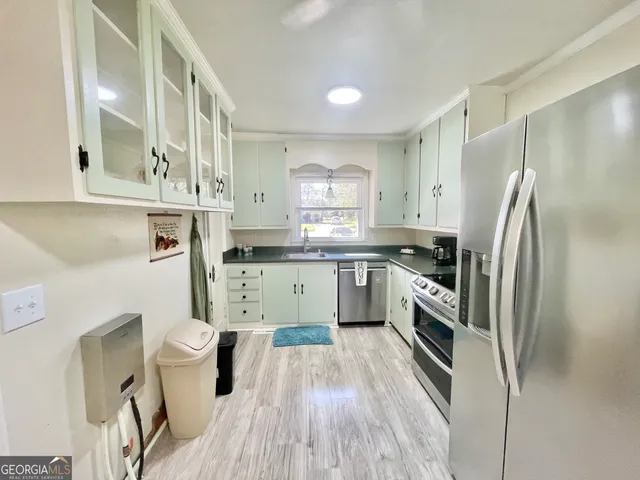 a kitchen with a sink a refrigerator a stove and cabinets