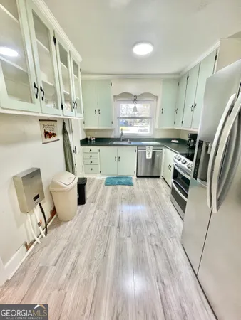 a kitchen with a sink dishwasher stove and cabinets