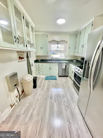 a kitchen with a sink dishwasher stove and cabinets