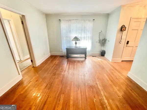 a view of a bedroom with wooden floor and a sink