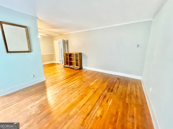 a view of an empty room with wooden floor