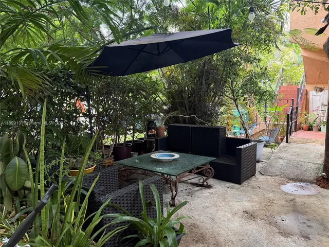a backyard of a house with table and chairs a barbeque with a fire pit