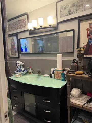 a room with painting on the wall and a mirror