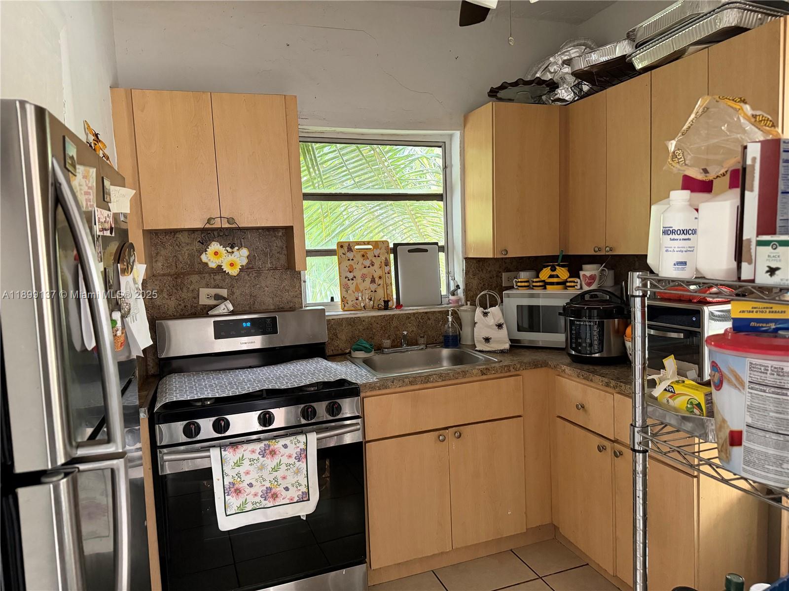 901 Southwest 19th Avenue Miami, FL 33135 - Photo 58 of 60 a kitchen with stainless steel appliances a stove refrigerator sink and cabinets
