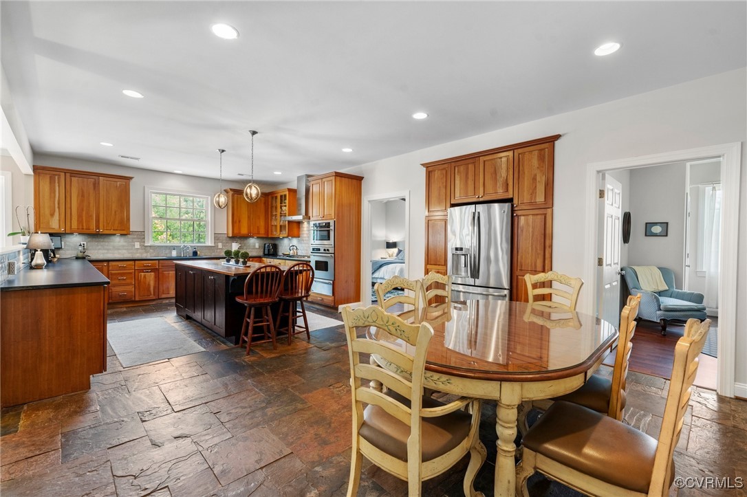 4060 Foxrun Road Powhatan, VA 23139 - Photo 11 of 50 a open dining room with stainless steel appliances kitchen island granite countertop a table chairs and a refrigerator