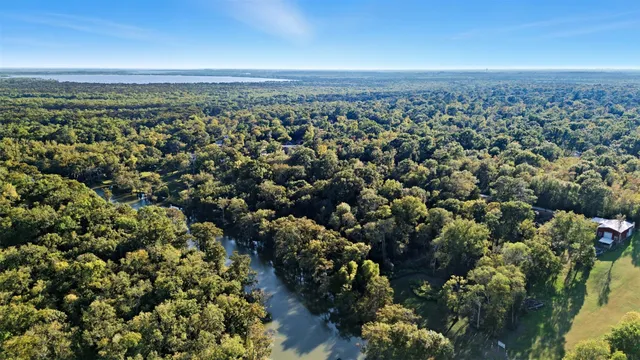 a dining room with chandelier fan and wooden floor