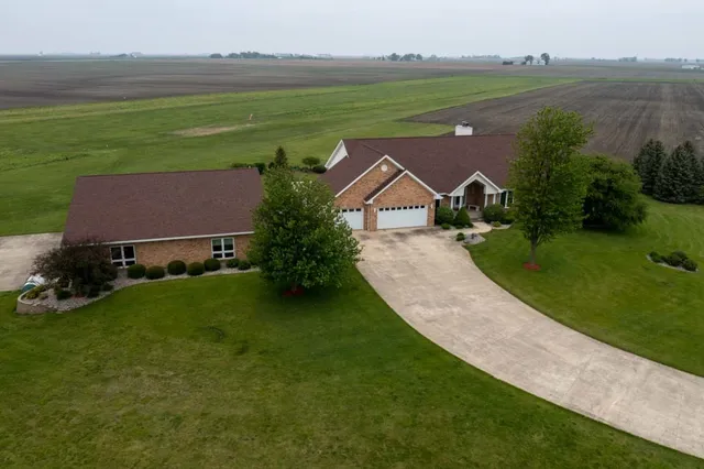 an aerial view of a house with a garden and lake view