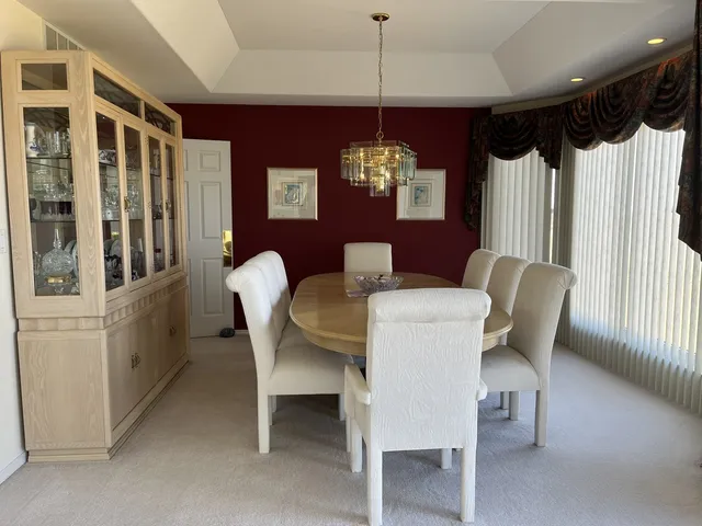 a dining room with furniture a chandelier and window