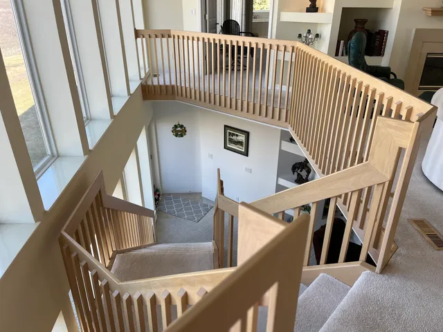 a view of staircase with railing and white walls
