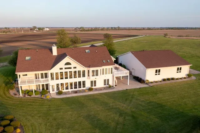 an aerial view of a house with a garden and lake view