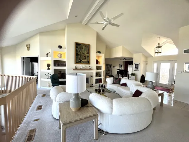 a living room with fireplace furniture and a view of kitchen