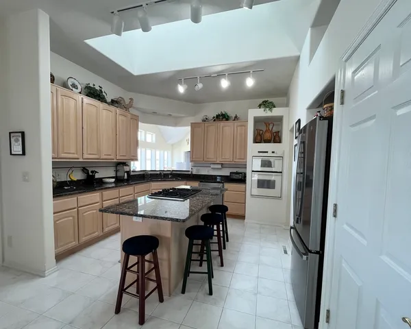 a kitchen with a refrigerator a sink and chairs