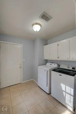 a utility room with cabinets washer and dryer