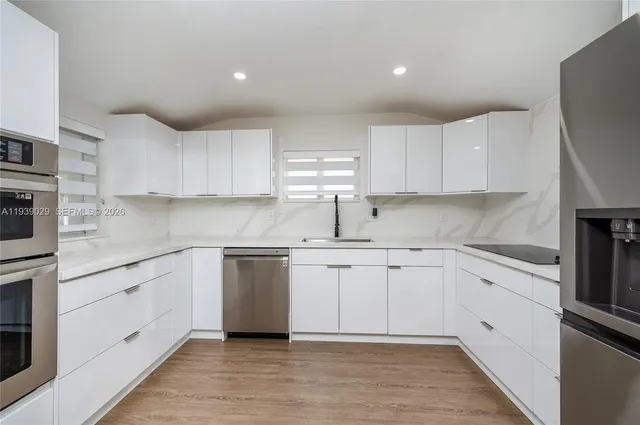 a kitchen with cabinets appliances and a sink