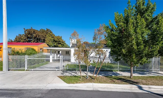 a view of a house with backyard and tree