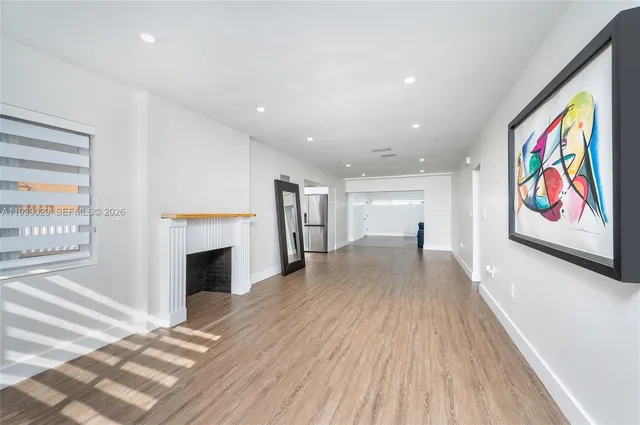 a view of an empty room with a fireplace and a window