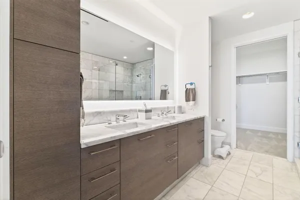 a bathroom with a double vanity sink mirror and shower