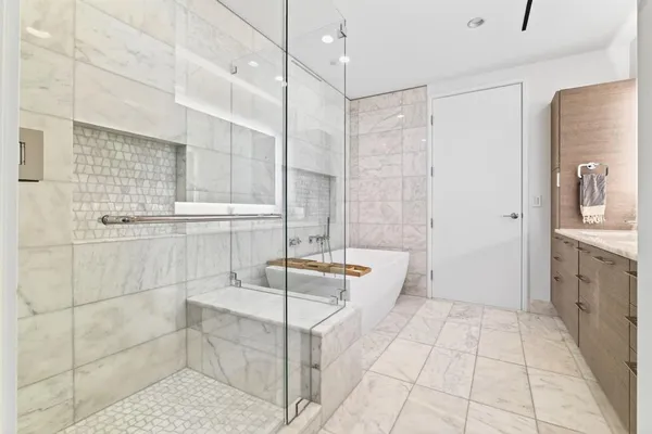 a bathroom with a tub shower and sink