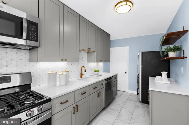 a kitchen with stainless steel appliances granite countertop a stove a sink and a microwave