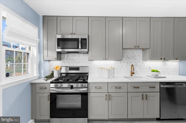 a kitchen with granite countertop white cabinets and stainless steel appliances