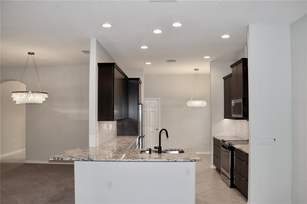 2389 Pawtucket Pass Mount Dora, FL 32757 - Photo 11 of 67 a bathroom with a granite countertop sink a large mirror and a refrigerator
